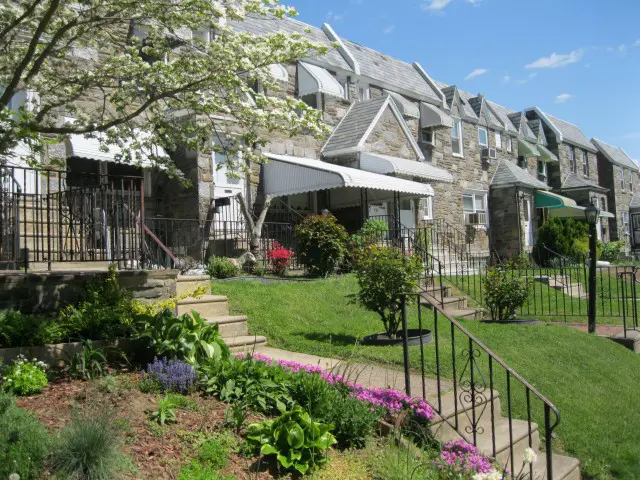 A row of houses with flowers in the front yard.