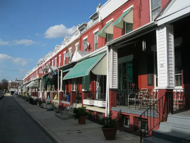 A row of red buildings with green awnings.