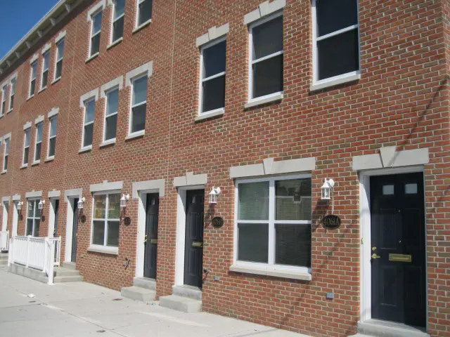 A row of brick houses with black doors.