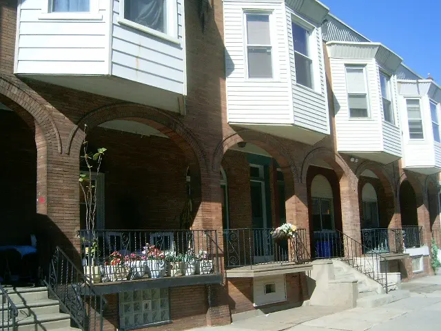 A brick building with flowers on the front steps.