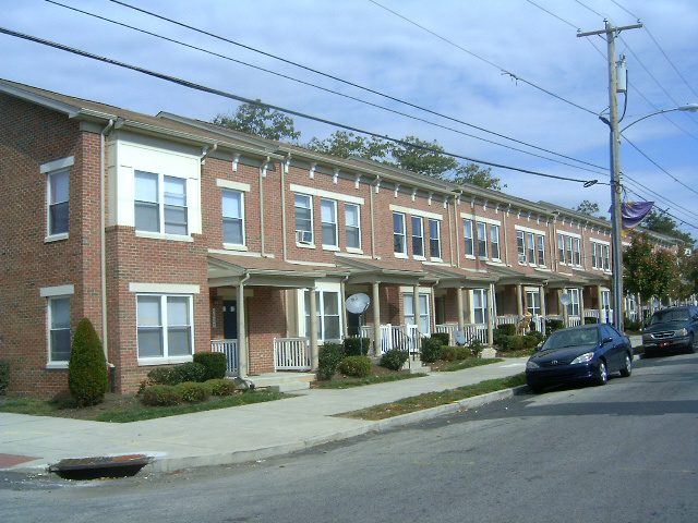 A row of brick houses on the side of a street.