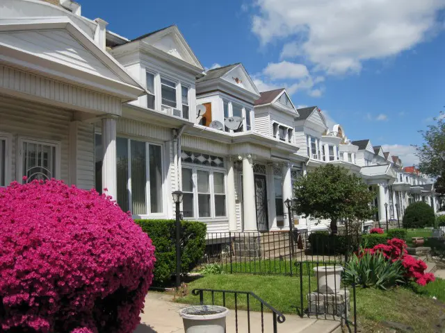 A row of houses with flowers in front.