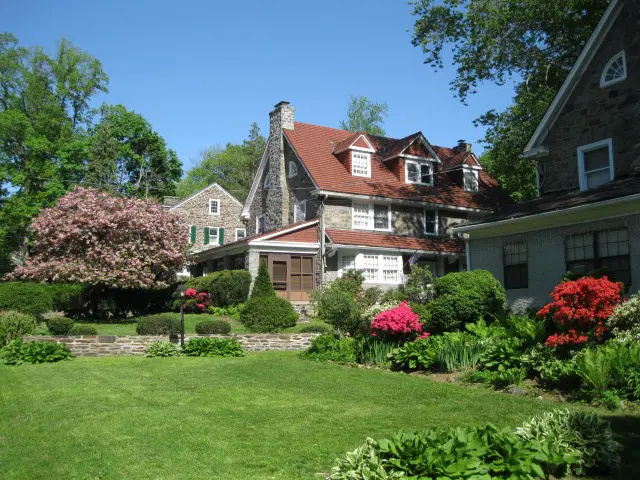 A large house with many flowers in the yard.